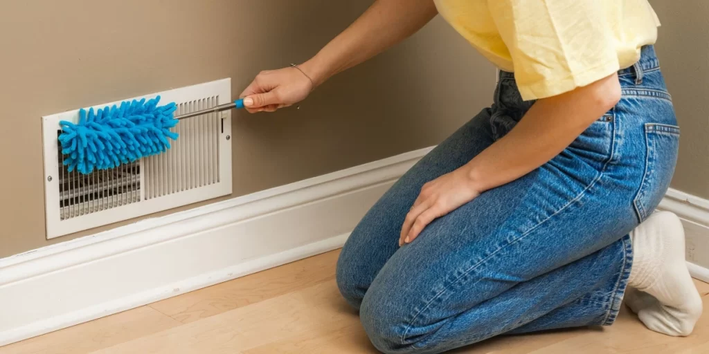 Cleaner removing dust from vents during spring cleaning