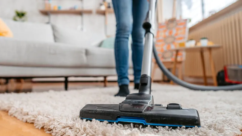 vacuum cleaning carpet to remove pollen allergens inside home